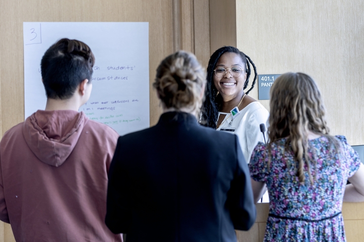 Graduate students and cohort members gather in a group of four for discussion
